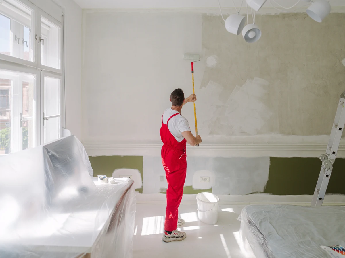 Hereford Painters decorator in red overalls working on a renovation interior